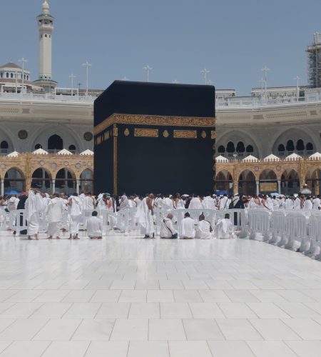 Pilgrims in traditional attire perform rituals around the Kaaba in Mecca, Saudi Arabia.
